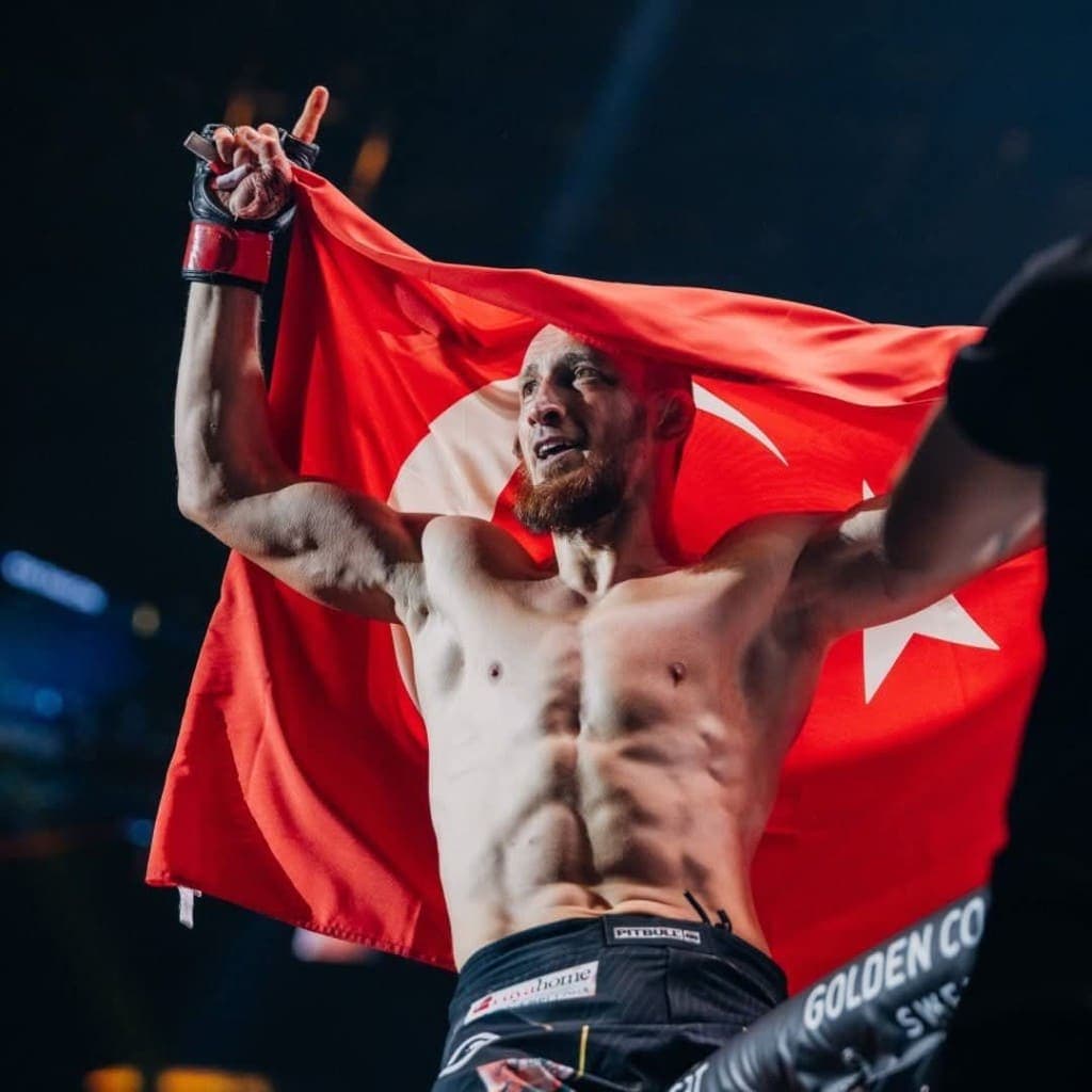 Gökhan Aksu after a win, the Turkish flag over his shoulders